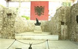 Tajuplným Balkánem do Albánie - Albánie - Lezhë, památník Skandeberga s jeho bronzovou bustou, vlajkou a maketami .zbraní, vpravo freska z 15.stol.